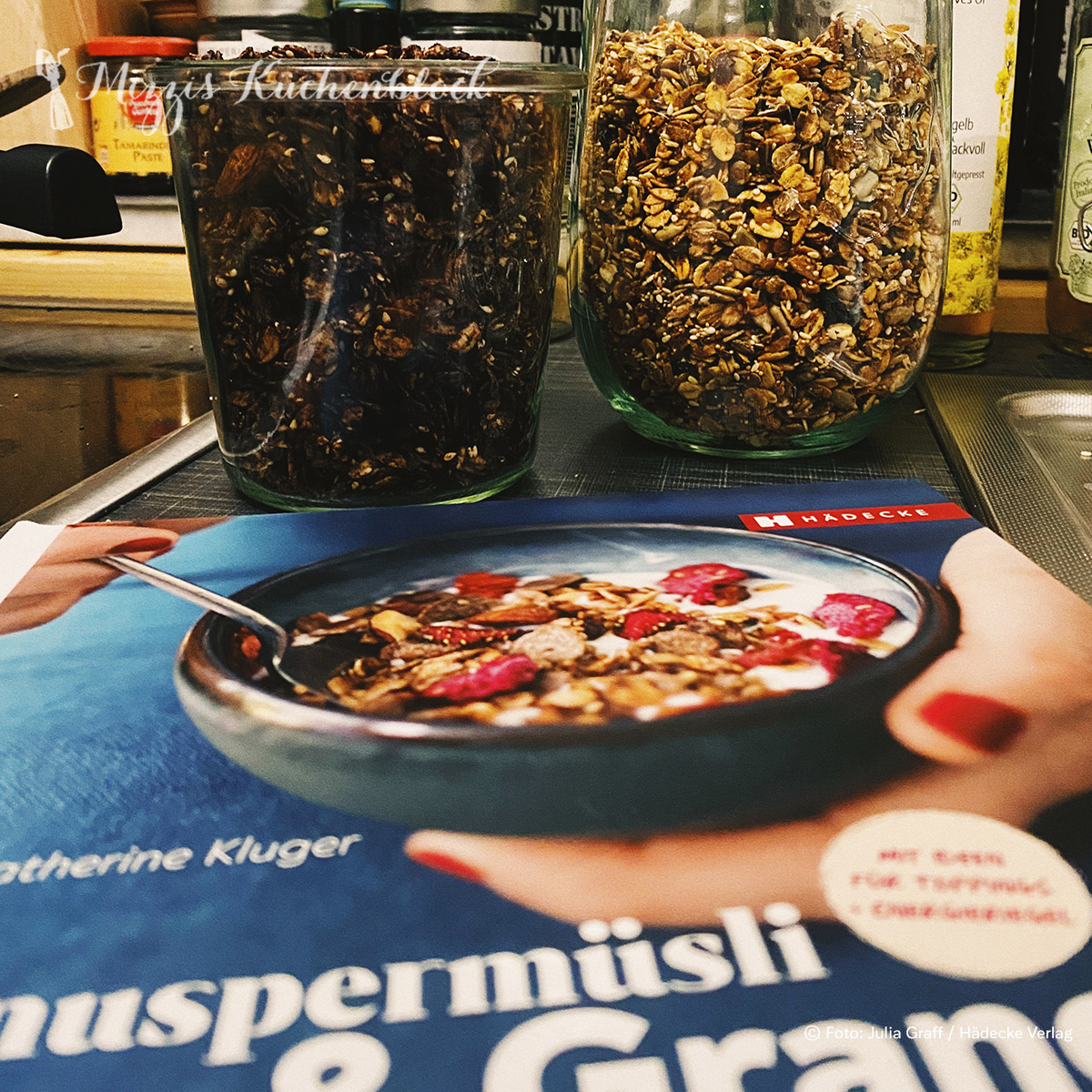 Zwei Gläser Granola und das Buch von Catherine Kluger „Knuspermüsli & Granola“ von Hädecke
